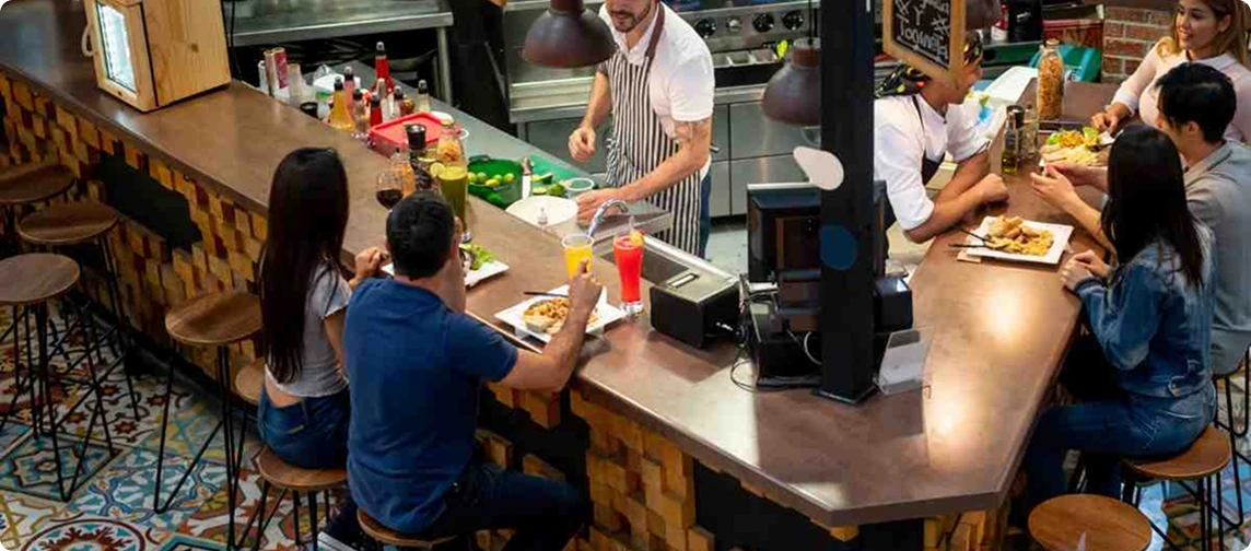 barra restaurante con garzon y personas comiendo