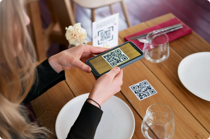 mujer escaneando qr en una mesa con platos