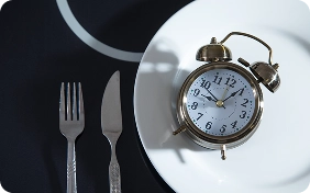 plato con tenedor cuchillo y despertador