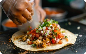manos de chef haciendo tacos